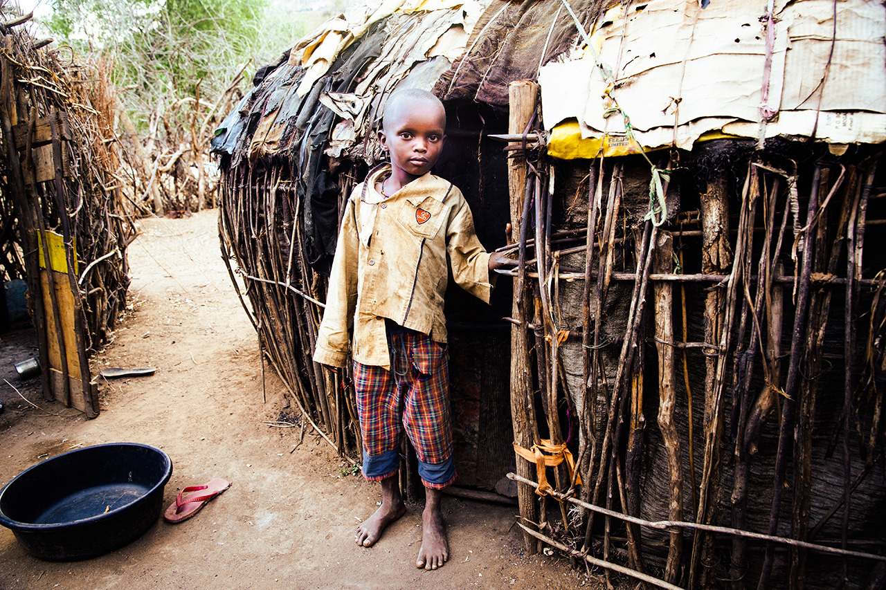 This sweet boy stands humbly outside his home near Kurungu in Kenya. A very typical sight. 
